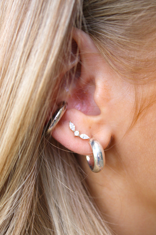 Silver-tone Luxe Mini Crawlers earring with clear marquise stones, styled on a model's ear alongside thick silver hoops.