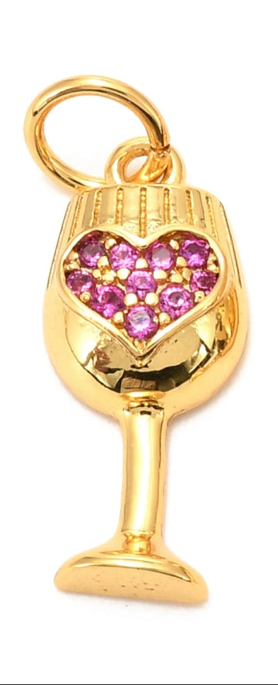 Gold-tone charm in the shape of a heart wine glass, featuring pink stones set in a heart design.