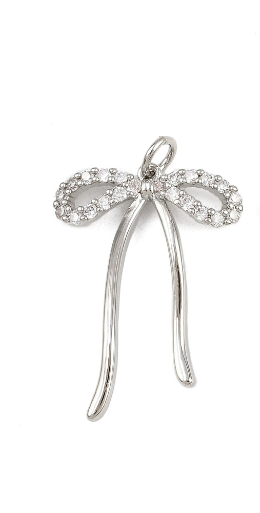 A silver bow charm featuring crystal-embellished loops and smooth, polished silver-tone ribbons on a plain white background.