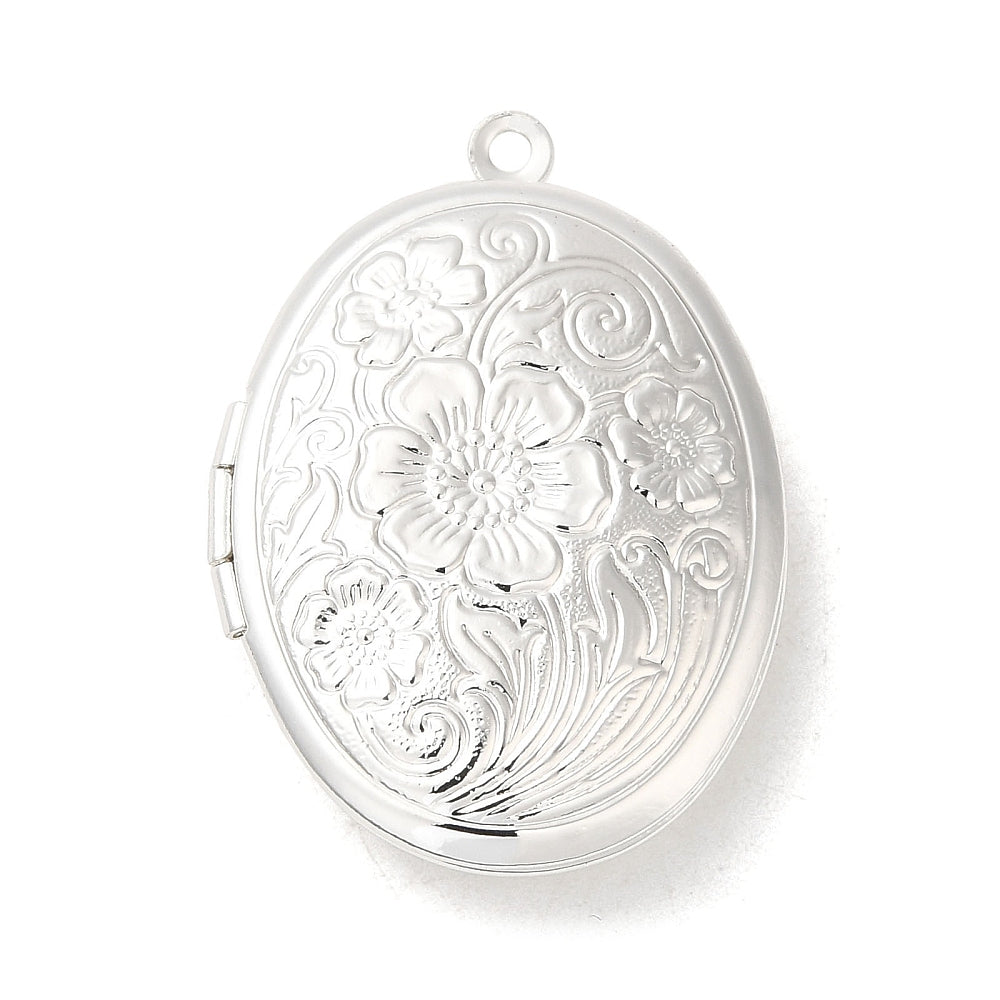 Oval silver locket charm with detailed embossed floral and scroll patterns, featuring a top loop for attachment.