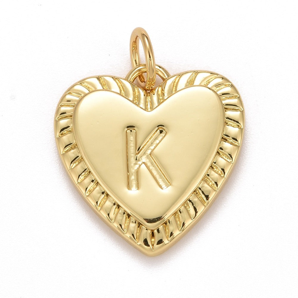 Gold-tone heart-shaped initial charm featuring an embossed letter K inside a smooth heart with a ribbed border.