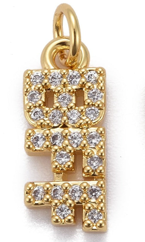 A gold-tone charm spelling BFF vertically, detailed with clear stones and a top bail ring.