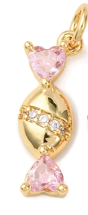 Gold-tone charm shaped like wrapped candy with pink heart-shaped crystals on both ends and a clear stone diagonal stripe.