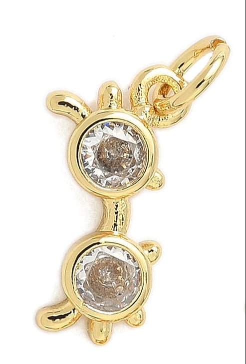 Gold sunglasses charm featuring two round, clear bezel-set crystals and a polished gold-tone jump ring.