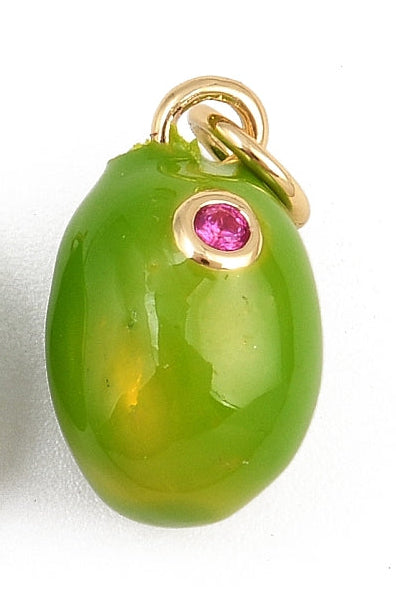 A glossy green olive charm with a small bezel-set pink gemstone and a gold-tone jump ring.