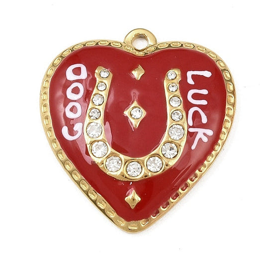Red enamel heart-shaped gold-tone charm with a rhinestone horseshoe, white 'GOOD LUCK' text, and a beaded gold border.