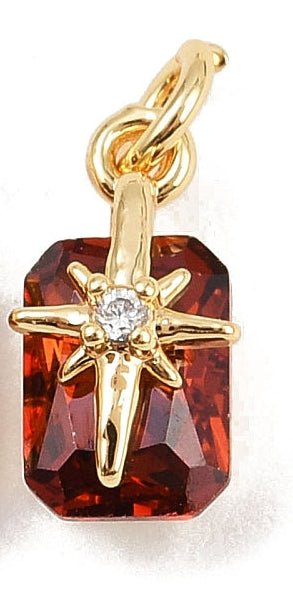 Ruby Star gold-tone charm featuring a rectangular faceted red stone overlaid with an eight-pointed starburst and a clear center gem.