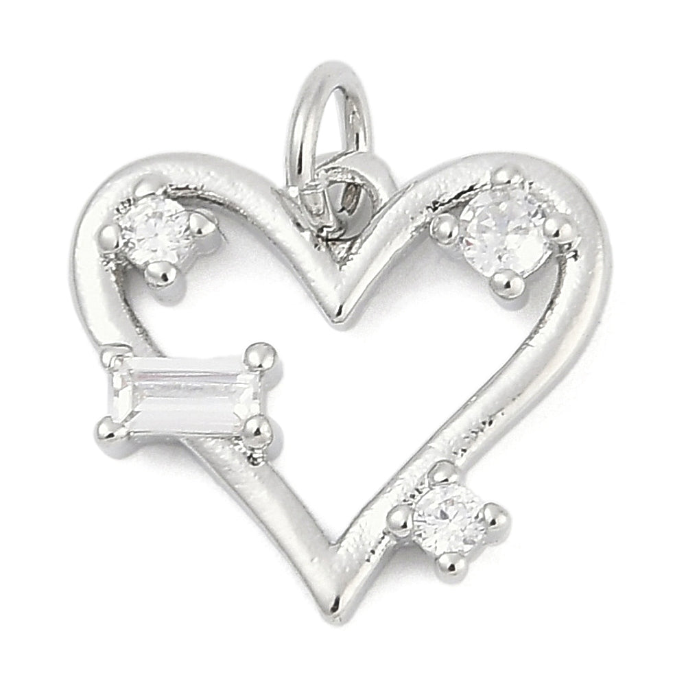 A silver heart charm featuring an open heart outline set with three round and one baguette clear stones.