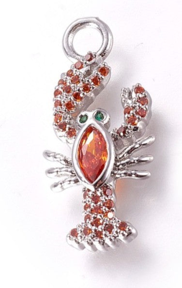 Silver lobster charm featuring a large marquise-cut orange center stone, orange pavé-set details, and green stone eyes.